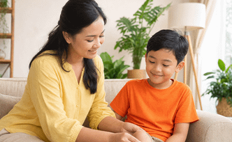 Ibu membersihkan luka lecet di lutut anak laki-laki berkaus oranye di sofa